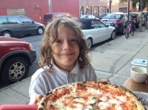 Jacob outside with pizza at Nomad Pizza Company